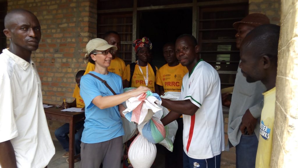 Mlle Juliette Maquart remettant un kit agricole à un chef de ménage bénéficiaire