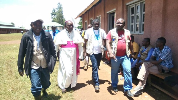 Visite de l’Evêque de Butembo-Beni au Centre de Traitement d’Ebola et à votre droite Emmanuel BOFOE (le tout premier debout) de Caritas Congo Asbl