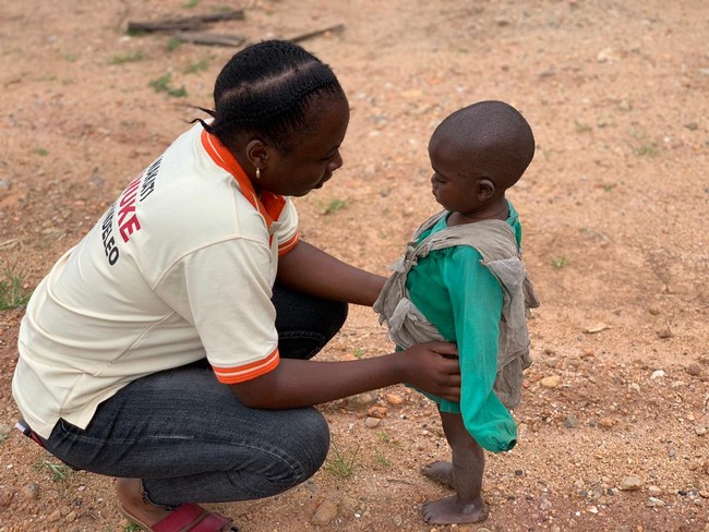 Mlle Chimène Mwanaweka réconfortant un enfant vulnérable à Jomba